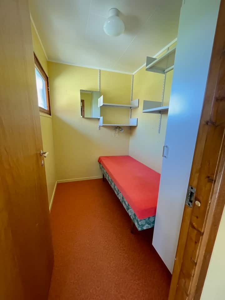 Stall with a bed by the entrance. Extra plate for dining table in the closet in this room.