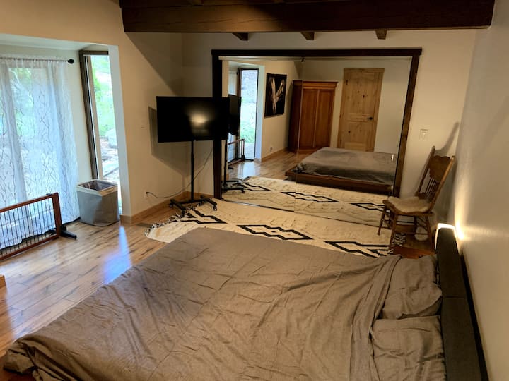 חדר שינה ראשי צמוד עם מיטת קינג סייז בסגנון יפני ונוף ליער. 