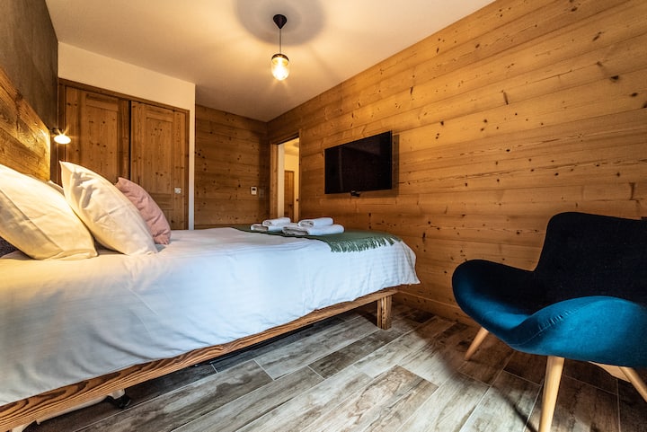Cama tamaño king construida a medida, mucho almacenamiento para ropa y maletas y un sillón extragrande para relajarse junto al patio.