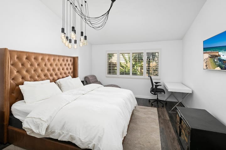 Chumba kizuri cha kulala cha msingi chenye dawati na televisheni