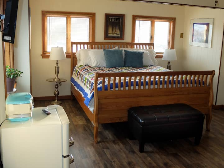 ห้องรับแขก 1 พร้อมเตียงเลื่อนขนาดคิงไซส์แคลิฟอร์เนียตู้เย็นขนาดเล็กวิทยุสมาร์ททีวีโต๊ะทำงานพอร์ต USB และตู้เสื้อผ้าขนาดใหญ่