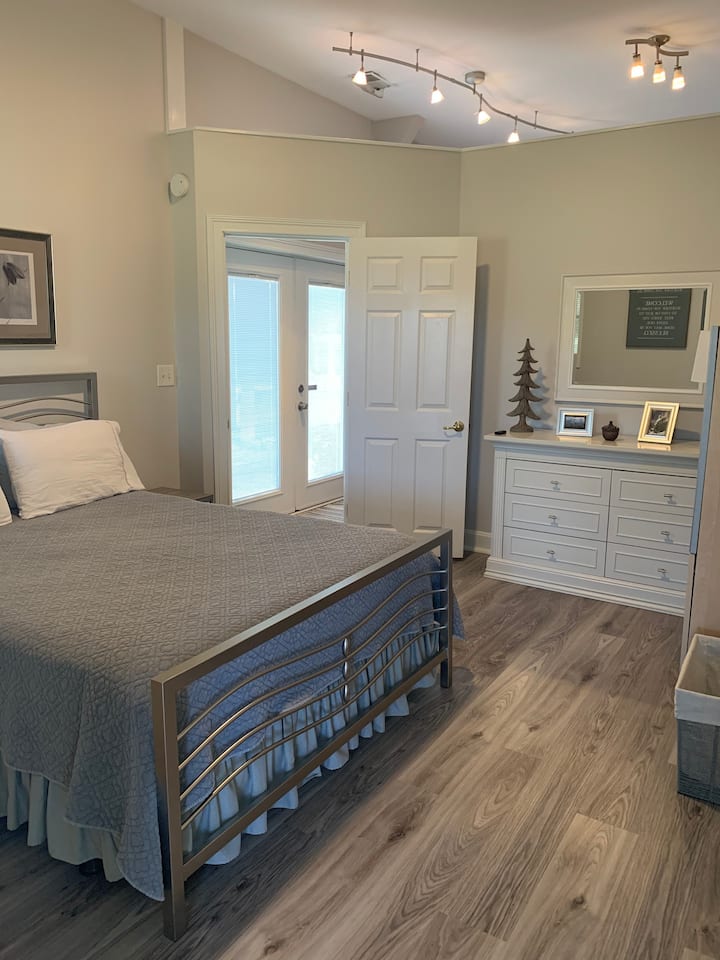 Chumba cha kulala kilicho na kitanda cha ukubwa wa malkia, kabati la kujipambia na kabati la kuingia lenye viango na nafasi kubwa ya kuhifadhi mizigo. 