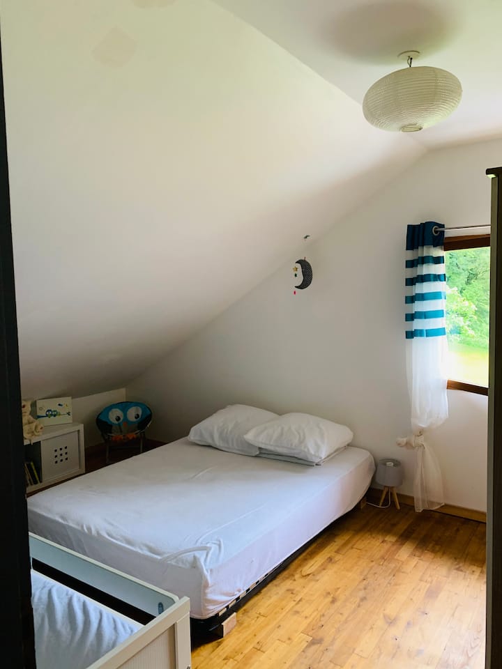 Dormitorio con una cama doble y una cama infantil.