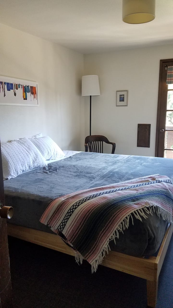 Room 12. One King Bed with Balcony and a sink.