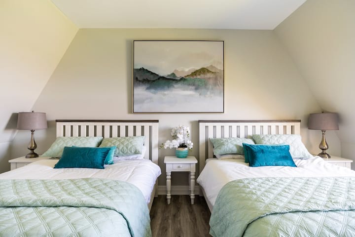 Upper floor bedroom with 2 queen beds, desk, toddler bed