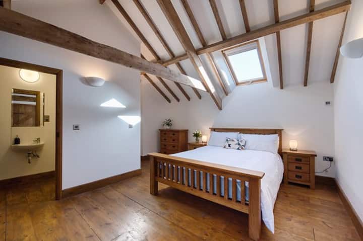 Dormitorio de arriba con cama king size y baño con ducha
