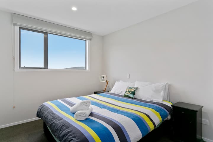 غرفة نوم بسرير بحجم كبير في الطابق العلوي