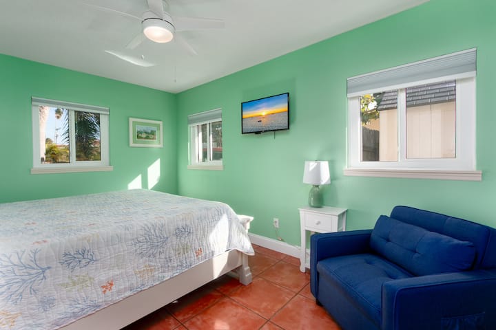 Kitanda cha ukubwa wa chumba cha kulala, televisheni na kiti cha kukunjwa.