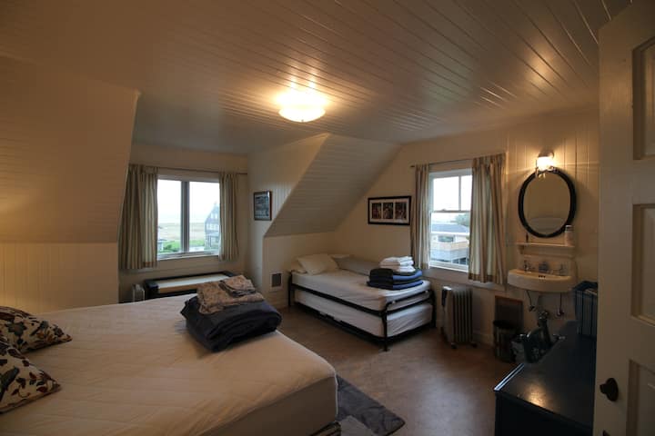 втори етаж NW ъгъл спалня/суперголяма спалня с изглед към океана, суперголямо двойно легло и две единични легла и мивка в стаята