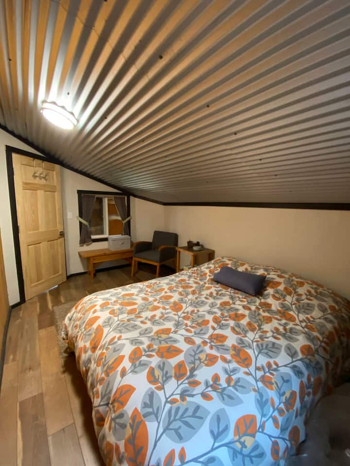 Тази спалня на горния етаж разполага с двойно легло с място за по - малки деца, които обичат да лагеруват на пода. 