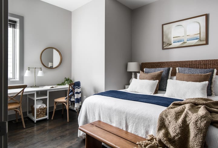Guest Bedroom has a King bed,  dedicated workspace area/vanity and is connected to a shared full bathroom.