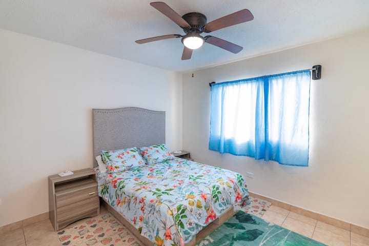 ห้องนอนใหญ่มีเตียงควีนไซส์พร้อมตู้แต่ละด้านของเตียงสำหรับโต๊ะท้ายหน้าต่างบานใหญ่ที่มีแสงสว่างเพียงพอเครื่องปรับอากาศพัดลมพร้อมไฟ
