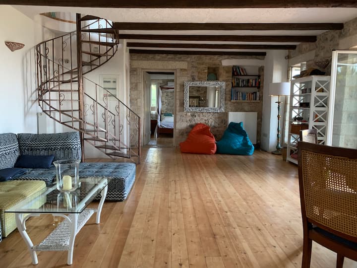 Sitting room with spiral staircase and exposed stone