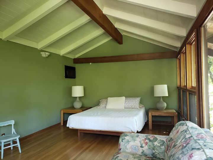 The upstairs bedroom has windows looking down on the garden. One queen bed and one queen foldout couch.
