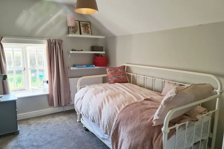 Smallest bedroom with a gorgeous view out to the garden and a trundle bed to fit two