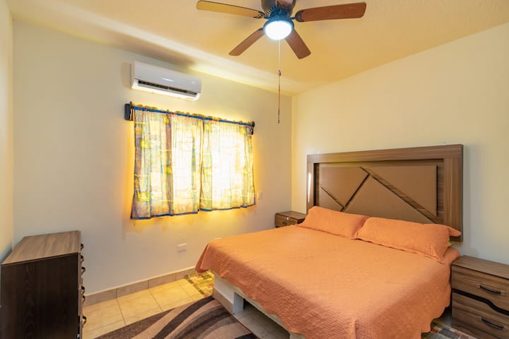 主卧配有舒适的加大双人床、空调（冬季暖气）、吊扇、通往后院的窗户、床两侧的桌子；以及抽屉。