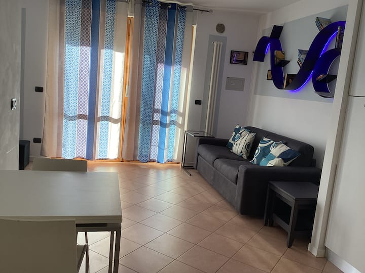 Një dhomë ndenjjeje me divan krevat që bëhet krevat dopio nëse është e nevojshme, e ndarë nga një perde nga krevati dopio. 