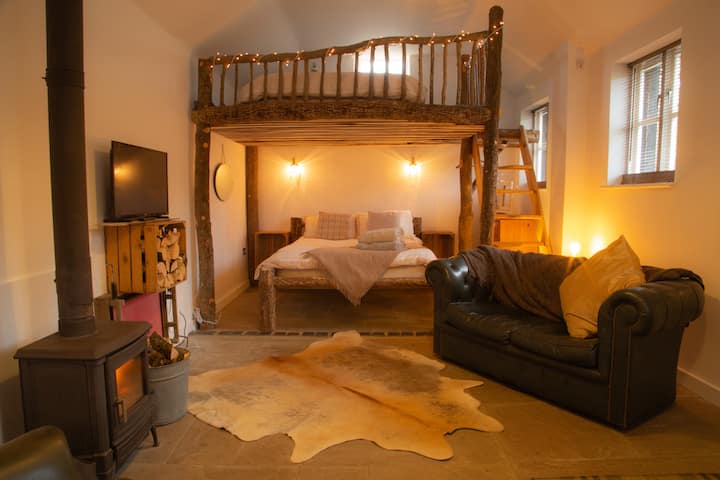 พื้นที่นั่งเล่นพร้อมเตียงคู่ด้านล่างและเมซซาไนน์สำหรับเตียงคู่ด้านบน