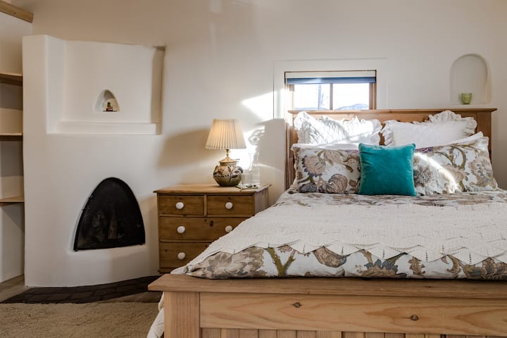 Upstairs, the queen bed in the master bedroom is super comfy. Guests may make wood fires in this fireplace during their stay. We provide fire wood. 