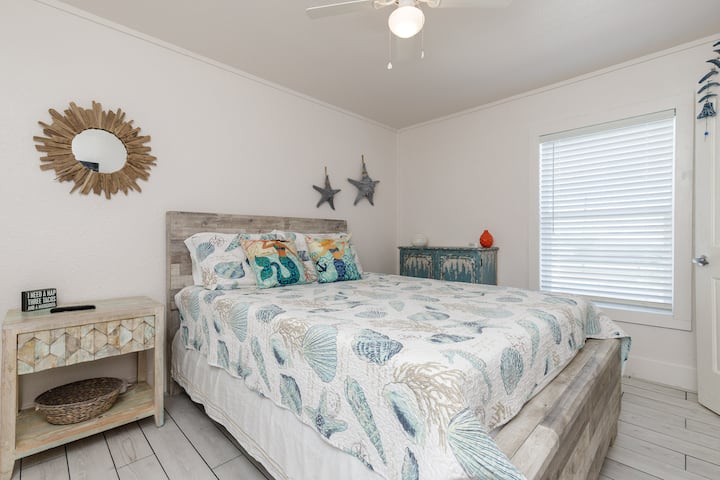 Bedroom One has a queen bed and tile flooring.