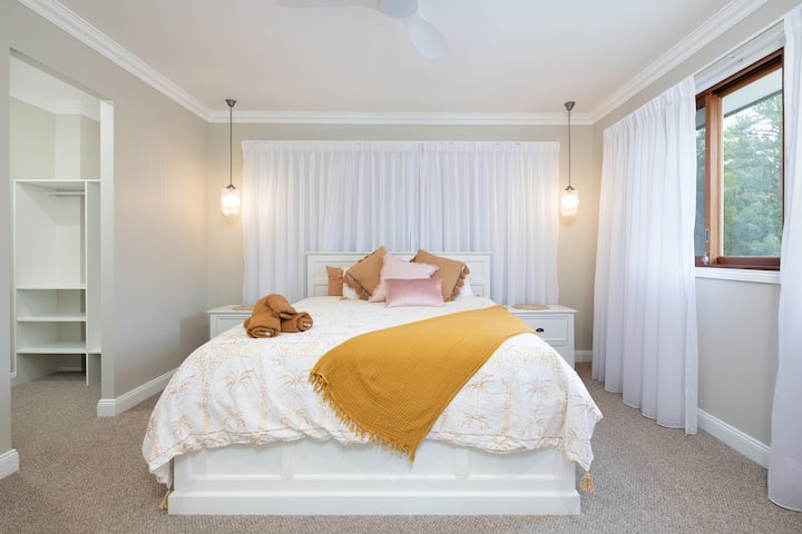 De grote slaapkamer met kingsize bed, dat uitkomt op een wandeling in badjas en luxe ensuite.