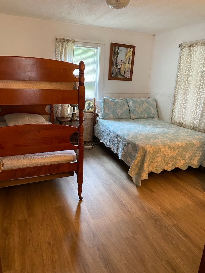 Cama doble con literas individuales en el dormitorio del segundo piso. 