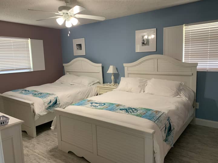 غرفة النوم الرئيسية – بسريرين بحجم كبير وخزانة ملابس وحمام رئيسي وتلفزيون بجوار. 