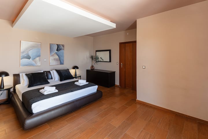 Queen-size bed (1.60 x 2.00), ensuite bathroom with a modern shower stall, in-room jacuzzi for relaxation, workspace with a desk