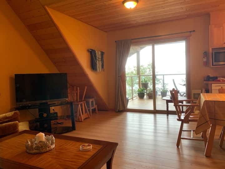 Bright Clean living room looking thru sliding glass patio doors onto private deck for you enjoyment.