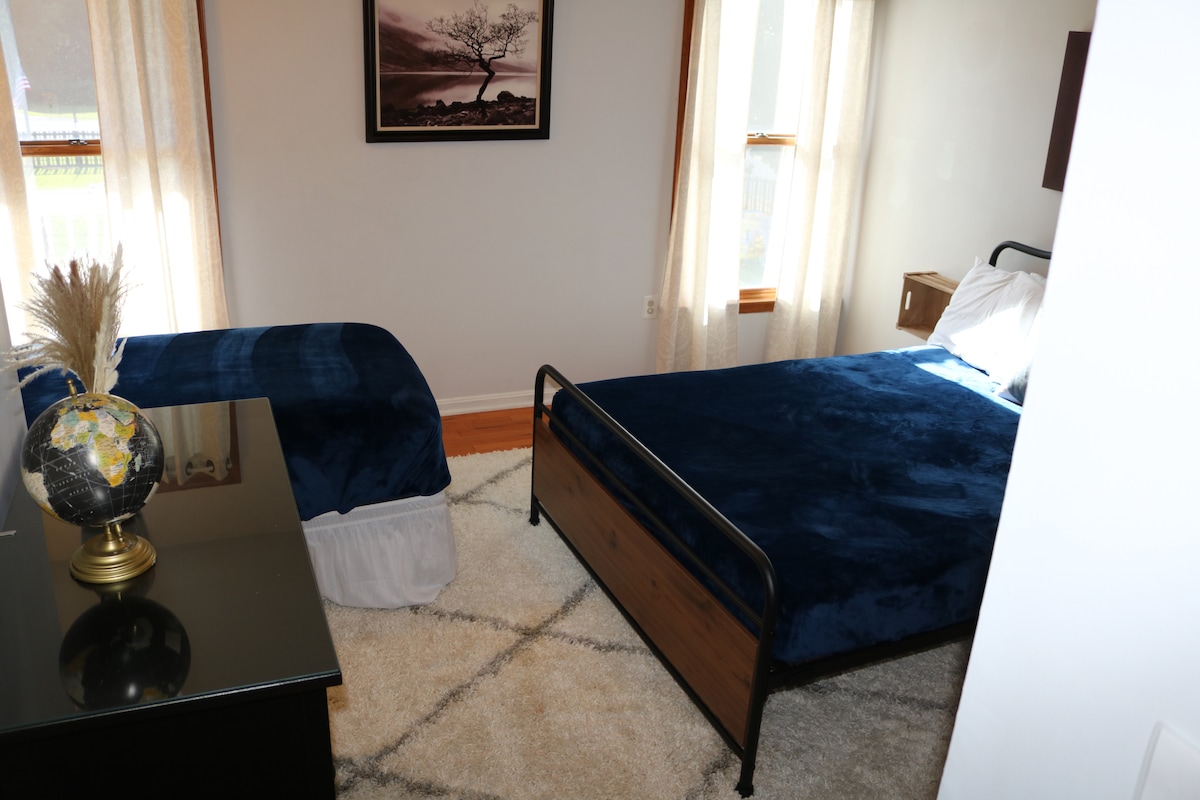 Kamer met queensize bed en twee eenpersoonsbedden, dressoir en kinderbed in de kast.