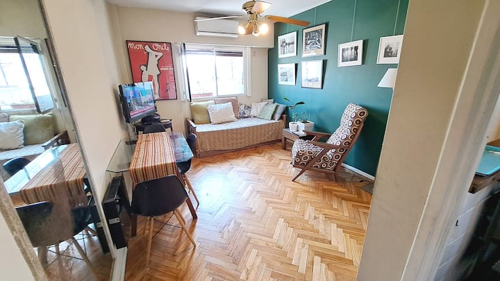 Uma sala de estar com meu sofá de leitura "olho" favorito, para descansar entre as caminhadas no bairro.