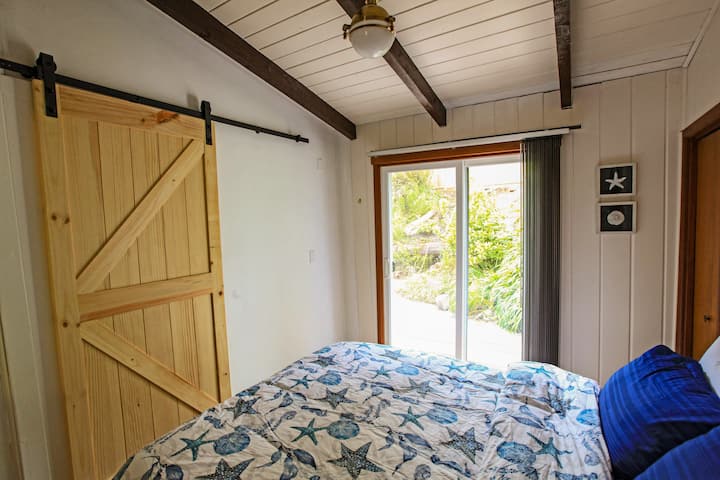Bedroom 2 with queen bed, and direct access to back porch and adjacent bathroom.