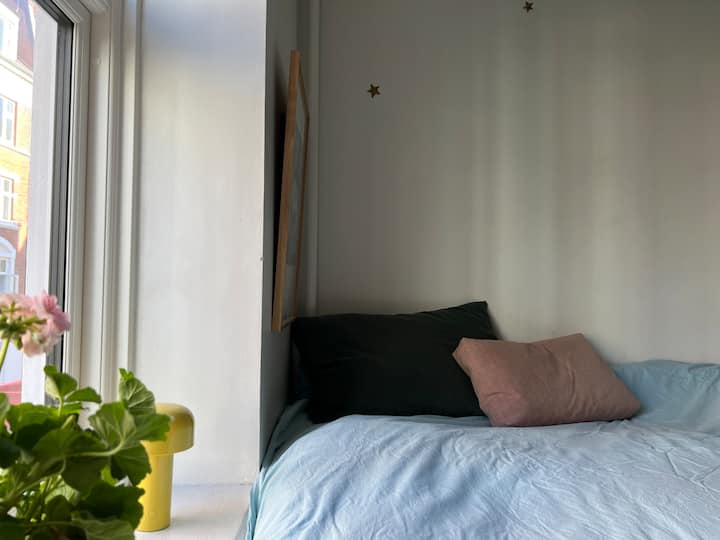 Acogedora cama alta de 140 cm con  vistas a la calle y a la luz del sol de la noche