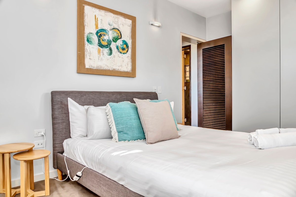 ห้องนอนหลักพร้อมเตียงควีนไซส์นุ่มๆและหัวเตียงผ้าปูที่นอนคุณภาพแบบโรงแรมและพื้นที่เก็บของมากมายสำหรับของของคุณ