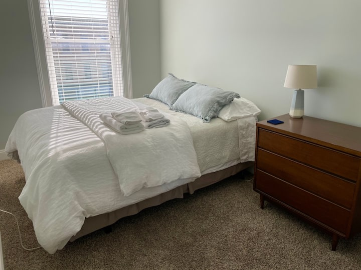 The second bedroom features a queen bed with a firm mattress and a memory foam mattress topper. There is a dresser, a small closet with ample hanging space and shelves. In the summer this bedroom also has a window AC to ensure a good night's sleep.