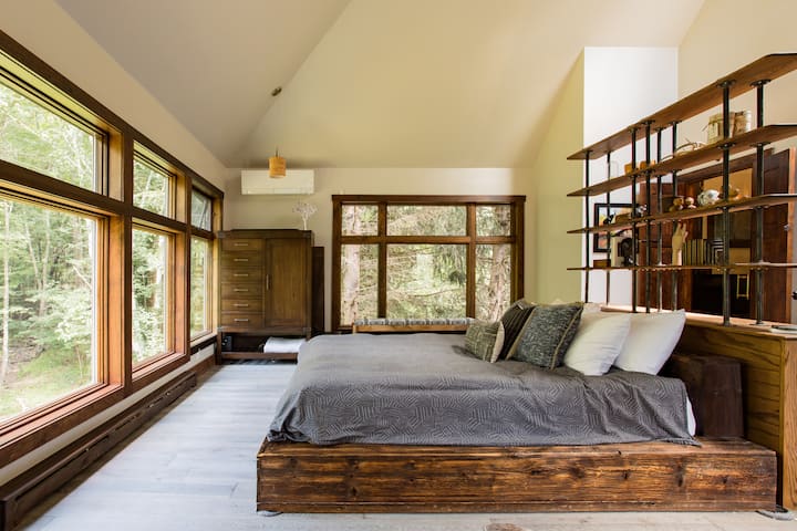 Bedroom #1 - Oversized Primary Bedroom with vaulted ceiling, en-suite spa-style bathroom, and a creek/forest view