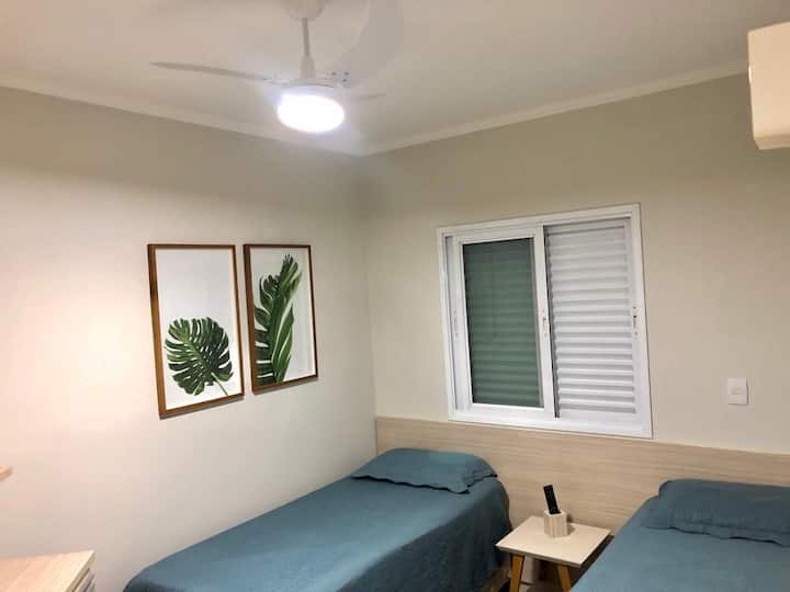 СПАЛНА СОБА СО КЛИМА УРЕД, ТАВАНСКИ ВЕНТИЛАТОР И ТЕЛЕВИЗОР.