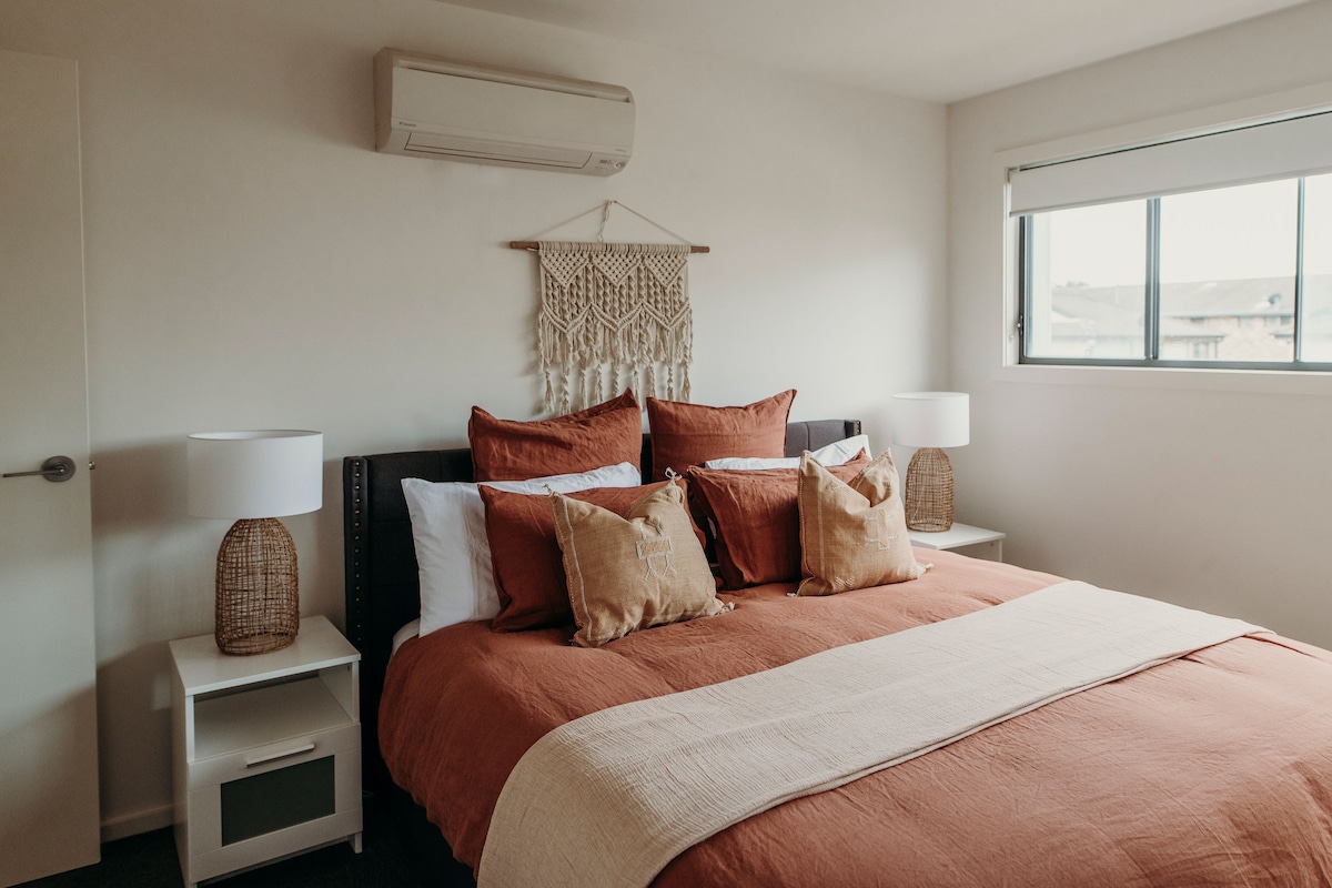 เตียงผ้าปูที่นอนสไตล์โบโฮขนาดคิงไซส์ในห้องนอนหลัก