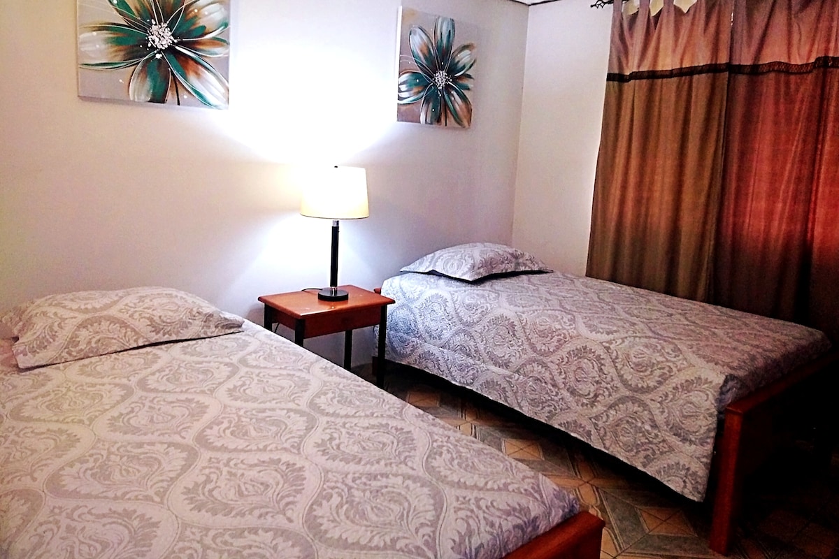 Spálňa s oddelenými posteľami a spoločnou kúpeľňou.