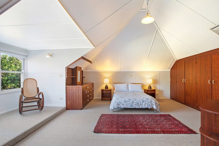 The bedroom in the attic at the top of the spiral staircase near the top of the home with a double bed.