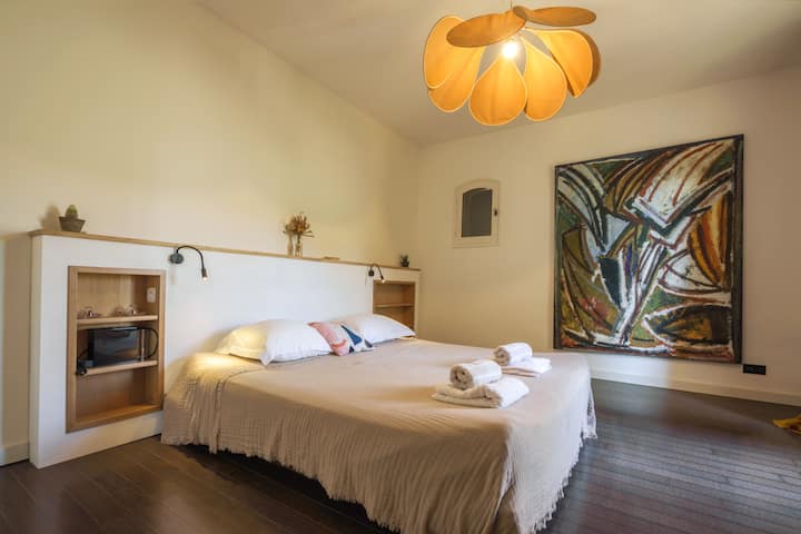 Kind bed with an attached italian shower and single sink. At the “garden and pool level”