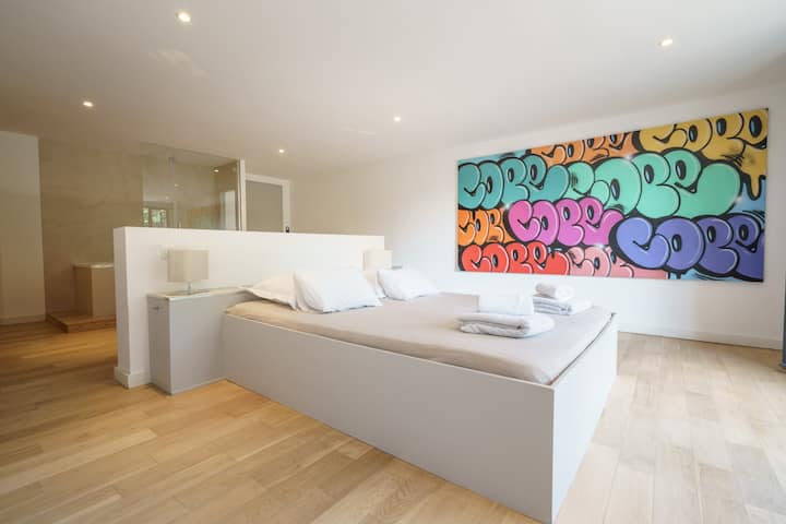 Kind bed with a bath tube, shower head and a single sink. Ground floor level