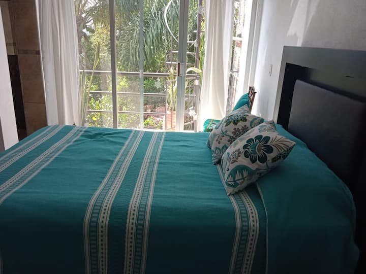 חדר שינה מרווח עם מרפסת המשקיפה על הגינה