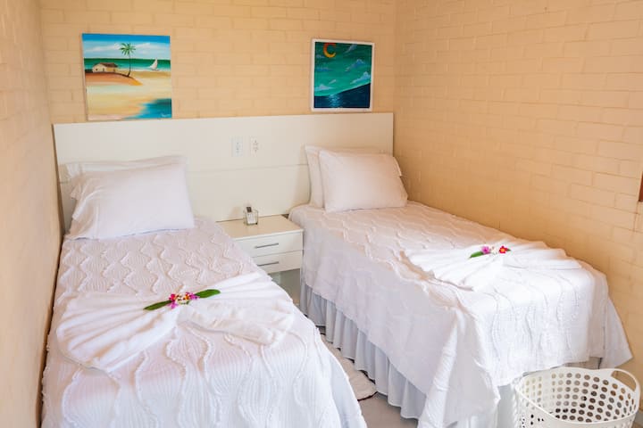 O quarto de hóspedes inclui banheiro privativo, duas camas de solteiro, ar-condicionado, escrivaninha, cortinas escuras e muito espaço no armário.