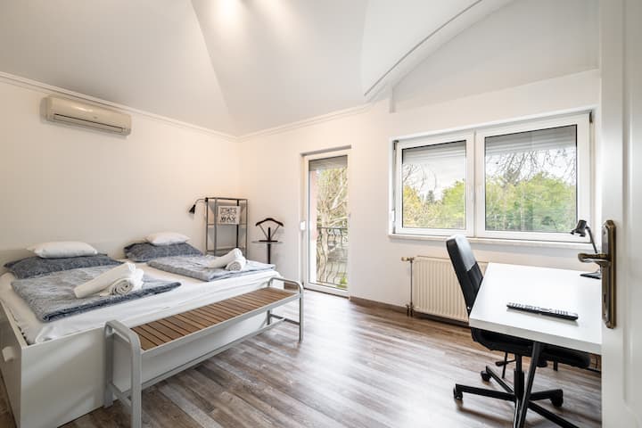 Dhomë gjumi super e madhe me tavolinë pune dhe televizor. Dhoma është përballë rrugës së qetë. 