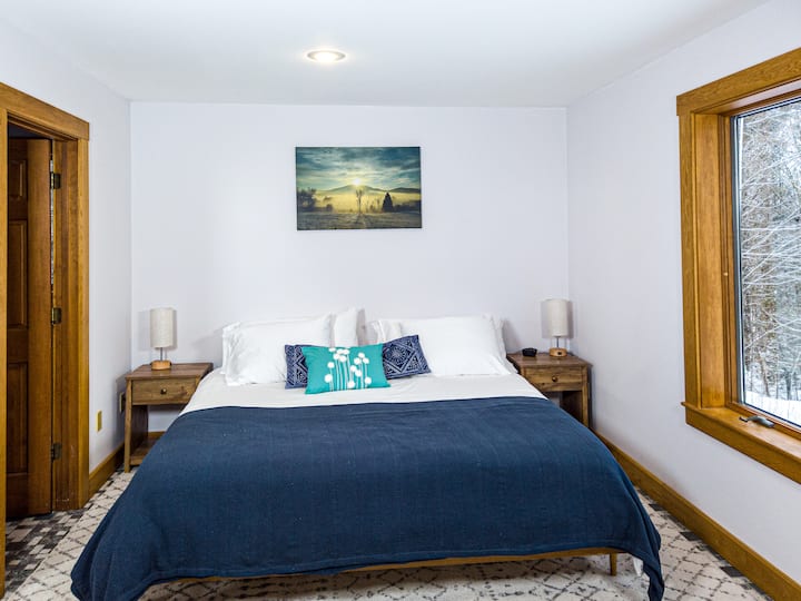 King size bed in the 1st floor master-so comfortable + lots of pillows. Featured is work by local photographer Karen Kennedy. 