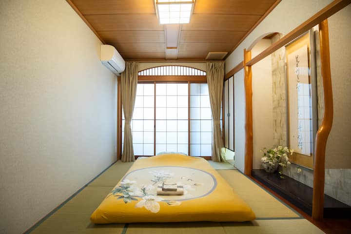 Საძინებელი 1: ეს არის ელეგანტური და მშვიდი იაპონური სტილის ტატამის საძინებელი, რომელიც იტევს ორ 1,5 მ სიგანის ტატამის მატრასს, თითოეული ლეიბი კომფორტულად იტევს 1-დან 2 ადამიანამდე, ხოლო მთლიანი საძინებელი იტევს მაქსიმუმ 4 ადამიანს.Ტატამის მასალა რბილი და სუნთქვადი, მაღალი ხარისხის მატრასებითა და თბილი ფუტონებით კომფორტული ძილისთვის.Ინტერიერი გრძელდება და სტილიც იგრძნობა, ხის კონსტრუქცია კი სივრცის მშვიდი შეგრძნებითაა გადაჯაჭვული.Იაპონური ნიშები და დეკორატიული გულსაკიდი შახტები საწოლის ბოლოში, რომელიც სავსეა ძენის სილამაზით.Იატაკიდან ჭერამდე ფანჯრები კარგად განათებულია, ფანჯრის გარეთ კი ცალკე აივანია, ასე რომ, შეგიძლიათ დაისვენოთ და დატკბეთ სიმშვიდით.Ეს შესანიშნავი ადგილია დასვენებისა და განტვირთვისთვის - იქნება ეს ოჯახთან ერთად გადაადგილება თუ მეგობრებთან ერთად სტუმრობა.