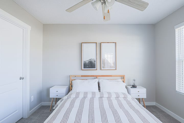 Chambre élégante avec décor neutre, matelas confortable et atmosphère relaxante pour des nuits reposantes.