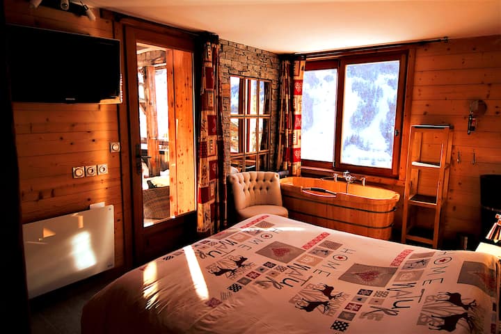 Chumba cha kulala 2 kwenye ghorofa ya kwanza kilichowekewa kitanda mara mbili. Bafu la chumbani lina beseni la mbao na ubatili wa mawe. Ufikiaji wa jakuzi na sauna ya Kifini ni kupitia mlango wa glasi.