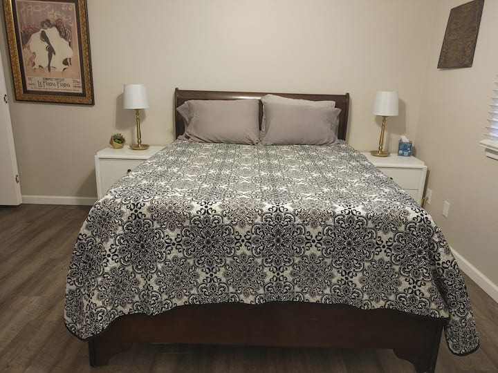 El dormitorio 1 tiene una habitación de temática francesa con cómoda cama tamaño queen,  muchas almohadas, puestos nocturnos, lámparas y una decoración divertida.